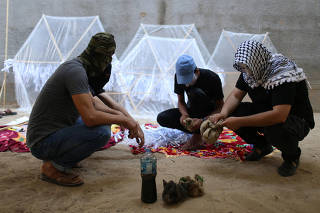 Palestinians prepare kites loaded with flammable material to be thrown at the Israeli side, near the Israel-Gaza border in the central Gaza Strip