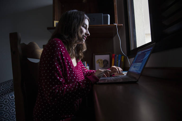 A psicóloga Letícia Gonçalves, 27, utiliza computador, com uma janela a sua frente