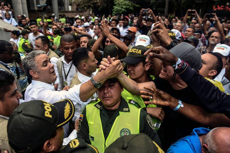O candidato à Presidência da Colômbia Iván Duque (de camisa branca) cumprimenta apoiadores em Medellín