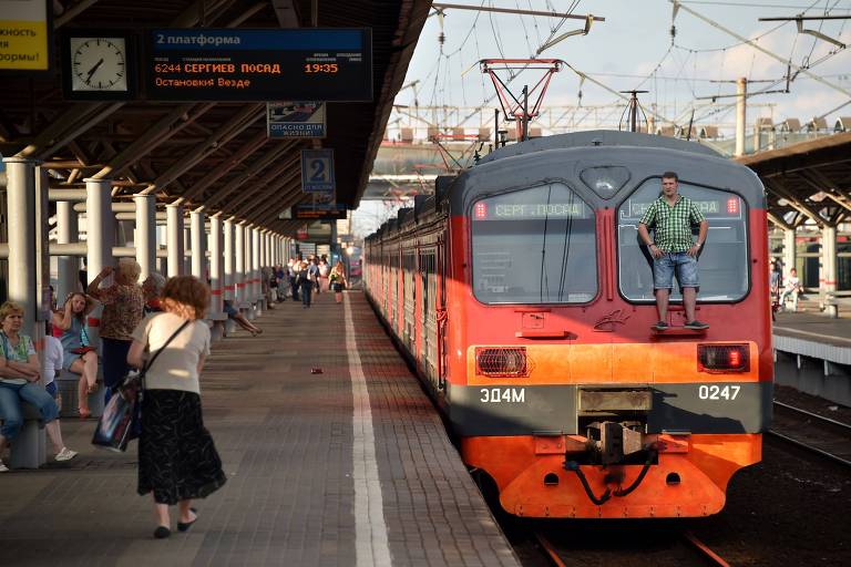 Homem fica de pé do lado de fora de trem no subúrbio de Moscou, na Rússia
