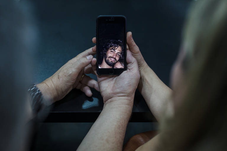 A esteticista Luciana Gomes, 47, e o representante comercial Carlos Marques, 56, seguram celular com a foto do filho Caio Sergio Gomes Marques, 24, estudante, que foi assassinado. Em Juiz de Fora, número de assassinatos explodiu na última década. Eram cerca de 30 casos até 2010. Em 2012, foram 67 mortes, desde então, todo ano registra mais de 100 vítimas. Em 2016, foram 135. Só até agosto de 2017 foram 87 casos, segundo a secretaria de Defesa Social de MG.