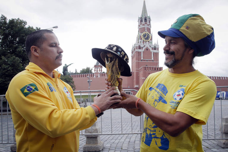 Brasileiros seguram réplica da taça da Copa do Mundo perto do Kremlin, em Moscou