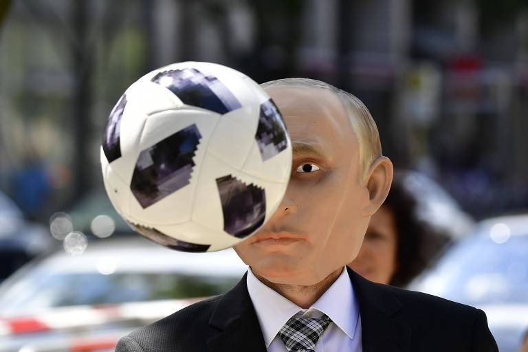 Ativista do Repórters sem Fronteiras veste máscara de Putin em protesto em frente à embaixada russa em Berlim, na Alemanha