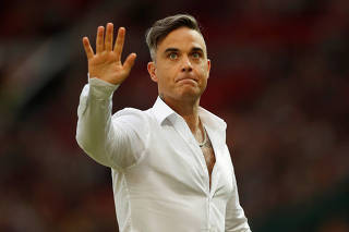 Robbie Williams acena antes de jogo da Inglaterra