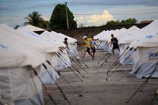 Venezuelan migrants play soccer between the tents in a UNHCR shelter in Boa Vista