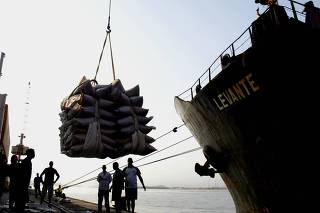 A ship is loaded with sugar sacks on the docks at port of Santos