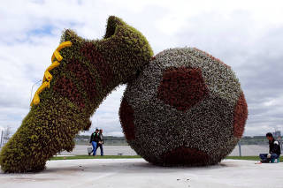 Workers give final touches at a decoration outside Kazan Arena
