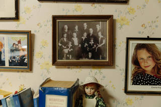 Family photos cover a wall in Miriam Tasini's home office, including one of her grandfather Jakub Finder and other relatives, in Los Angeles.