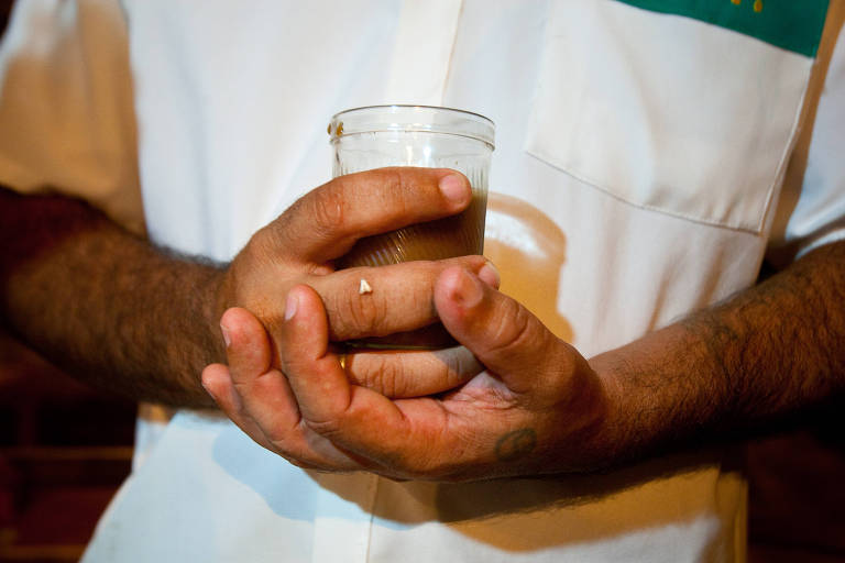 O chá ayahuasca servido em um copo a dependentes durante culto