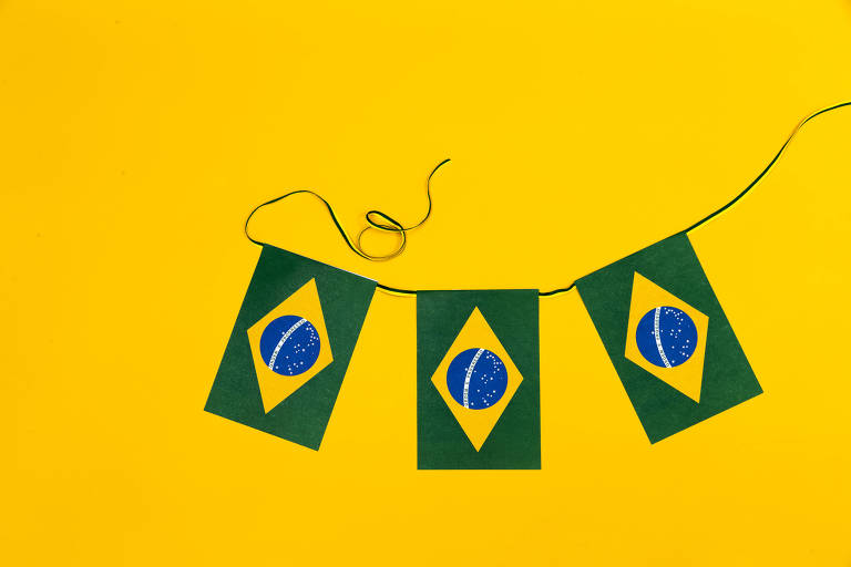 Três bandeiras do Brasil pequenas e presas em uma corda