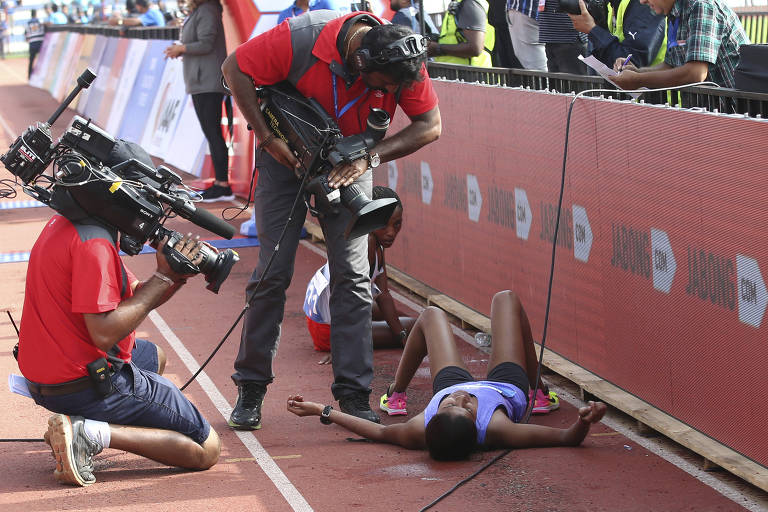 Equipe filma mulher que caiu no chão após cruzar a linha de chegada de corrida