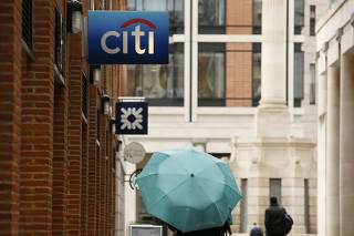 People walk past a Citibank branch in the City of London