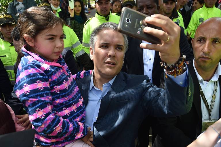 Iván Duque, presidente eleito da Colômbia, tira selfie com garota depois de votar, neste domingo (17), em Bogotá