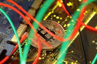 FILE PHOTO: Representation of the Bitcoin virtual currency standing on the PC motherboard is seen in this illustration picture