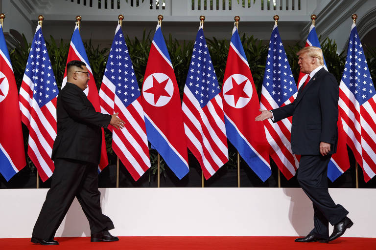 O presidente Donald Trump e o ditador norte-coreano Kim Jong-un caminham para aperto de mão histórico em reunião em Singapura, em 12 de junho