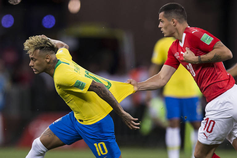 O atacante Neymar tem sua camisa puxada pelo suíço Xhaka , na partida de estreia do Brasil na Copa do Mundo da Rússia