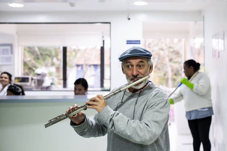 O flautista Toninho Carrasqueira toca pelos corredores do hospital