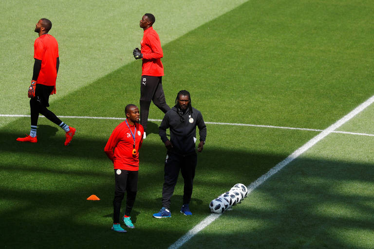 O treinador de Senegal, o ex-jogador Cissé, à dir., ao lado de assistentes durante treino no estádio Spartak 