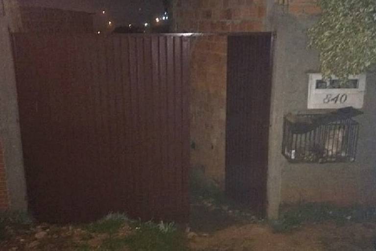 Imagem escura mostra casa com portão aberto