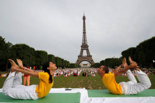 People gather for an open-air yoga session near the Eiffel tower in Paris