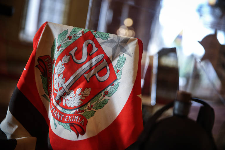 Bandeira com o brasão de armas de São Paulo, adotado em agosto de 1932, com a inscrição Pro São Paulo fiant eximia (Por São Paulo façam-se grandes coisas). A ideia não foi aprovada pelo então governador e São Paulo foi substituído por Brasil na inscrição