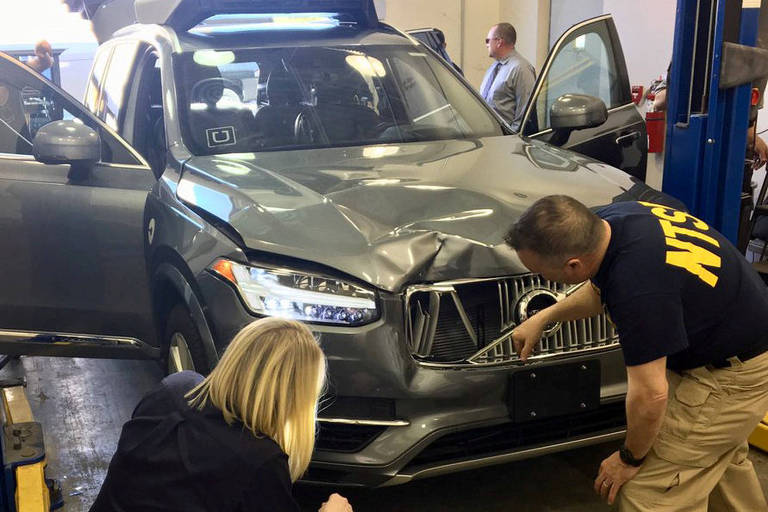 FILE PHOTO: Handout photo of NTSB investigators examining a self-driving Uber vehicle involved in a fatal accident in Tempe