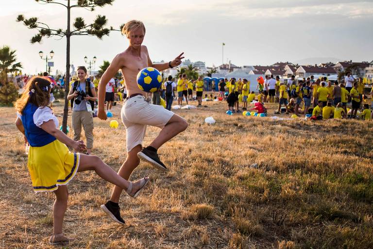 Torcedores suecos brincam de bola no lado de fora do estádio olímpico de Fisht em Sochi 