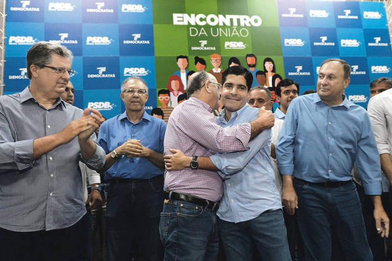 À esquerda, o tucano Jutahy Junior observa o pré-candidato do DEM ao governo baiano, José Ronaldo, abraçar o prefeito de Salvador, ACM Neto, em encontro em maio