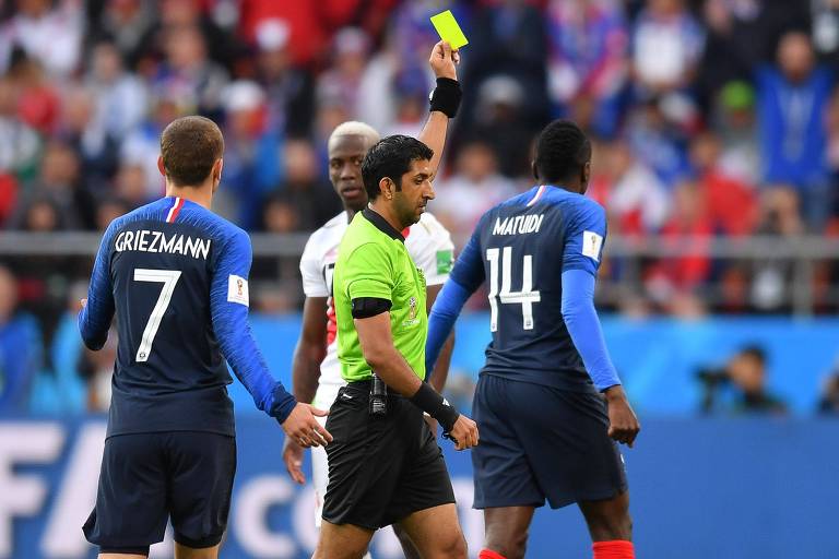 O árbitro Mohammed Abdulla Mohammed adverte Matuidi, da França, com cartão amarelo