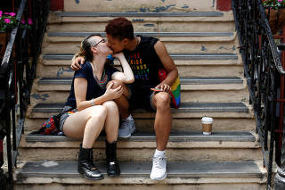 Davy Ran kisses their partner James Brice on a stoop before the 2018 New York City Pride Parade in Manhattan, New York