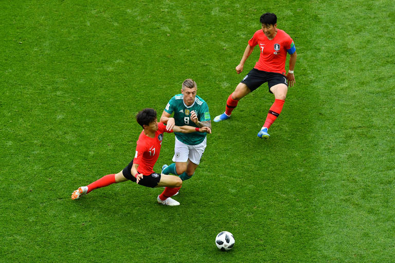 O alemão Toni Kross tenta escapar da marcação de dois jogadores sul-coreanos