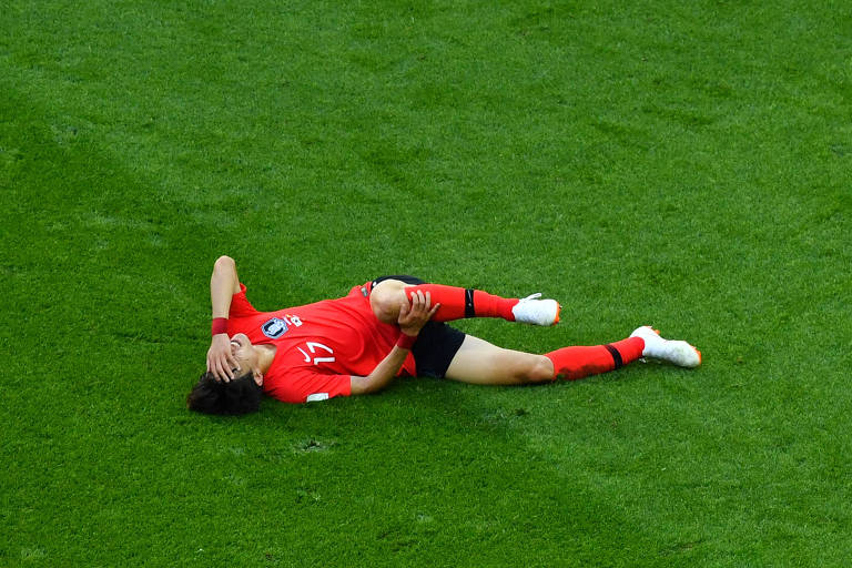 Lee Jae-sung, da Coreia do Sul, caído no gramado