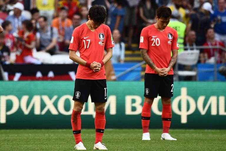O meia Lee Jae-sung e o zagueiro Jang Hyun-soo rezam no início do segundo tempo