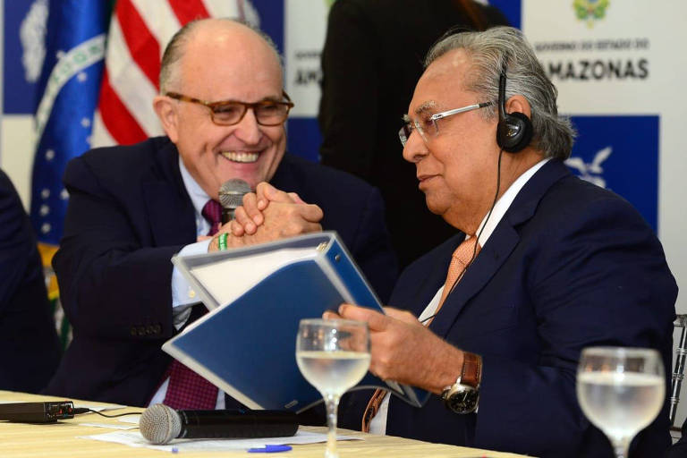 O ex-prefeito de NY Rudolph Giuliani (à esquerda) entrega documento ao governador do Amazonas, Amazonino Mendes