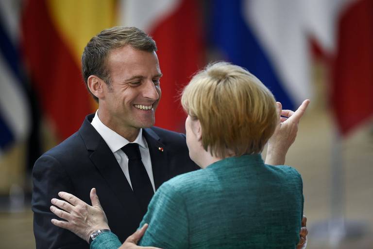 A chanceler alemã Angela Merkel (de costas) e o presidente francês Emmanuel Macron se cumprimentam durante o encontro em Bruxelas 