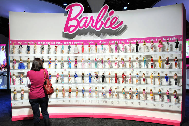 Mulher observa estande com bonecas Barbie, fabricadas pela Mattel