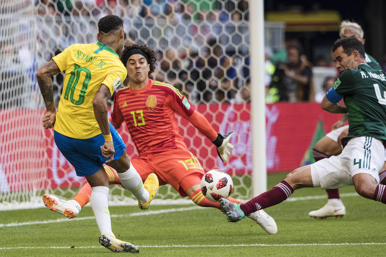 Neymar chutando para o gol enquanto Ochoa, goleiro do México, tenta defender; ao lado, jogador do México tenta impedir Neymar.