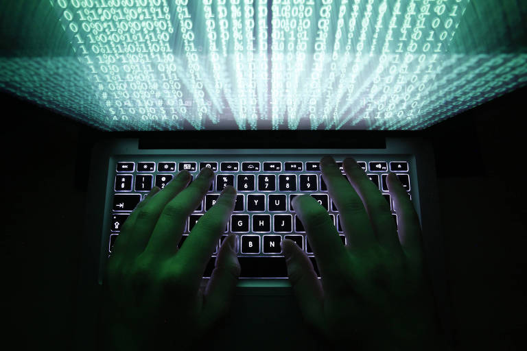 Foto mostra as mãos de um homem digitando em um teclado de computador