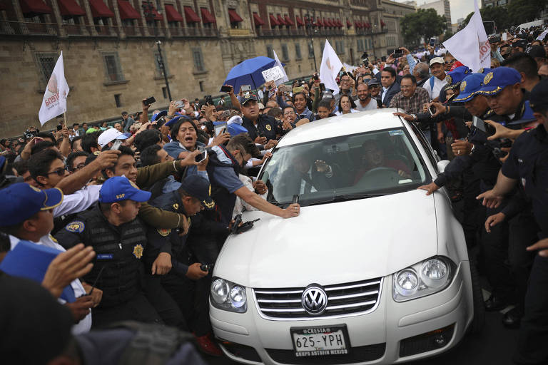 Policiais fazem segurança de Andrés Manuel López Obrador (dentro do carro) ao deixar encontro com Enrique Peña Nieto, na Cidade do México
