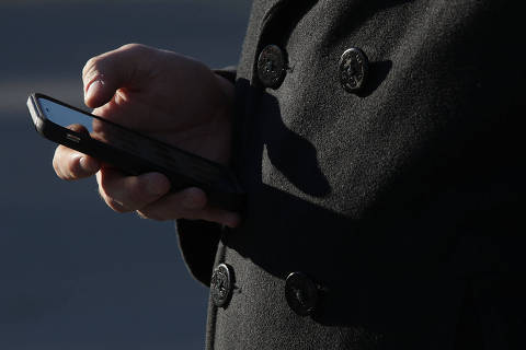 (FILES) In this file photo taken on November 29, 2017, a  man checks his cell phone as he waits in line to enter the US Supreme Court to view a hearing in Washington, DC, Carpenter v. United States on whether prosecutors violated the Fourth Amendment by collecting a criminal suspect's cellphone location and movement data without a warrant.  
In a landmark digital privacy case, the US Supreme Court ruled Friday, June 22, 2018, that police need a warrant before obtaining cell phone location data about a suspect from telecom companies. In a 5-4 decision, the nation's highest court said that cell phone location data is protected under the Fourth Amendment, which guards against unreasonable search and seizure. The case stemmed from the police acquiring mobile phone location information about a robbery suspect without a warrant.

 / AFP PHOTO / GETTY IMAGES NORTH AMERICA / ALEX WONG