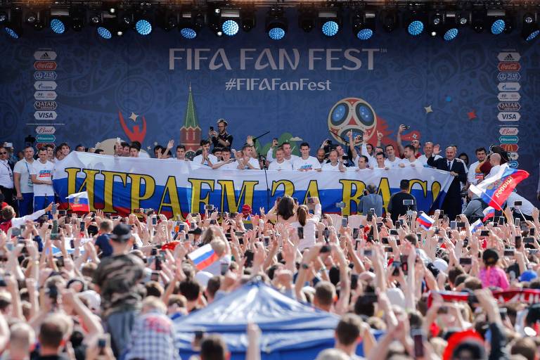 Jogadores russos com faixa com a frase "Jogamos por vocês!" durante homenagem para a seleção em fan fest em Moscou