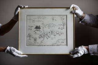 FILE PHOTO: Sotheby's staff hold the original map of Winnie the Pooh's Hundred Acre Wood by E.H. Shepard at Sotheby's auction rooms in London