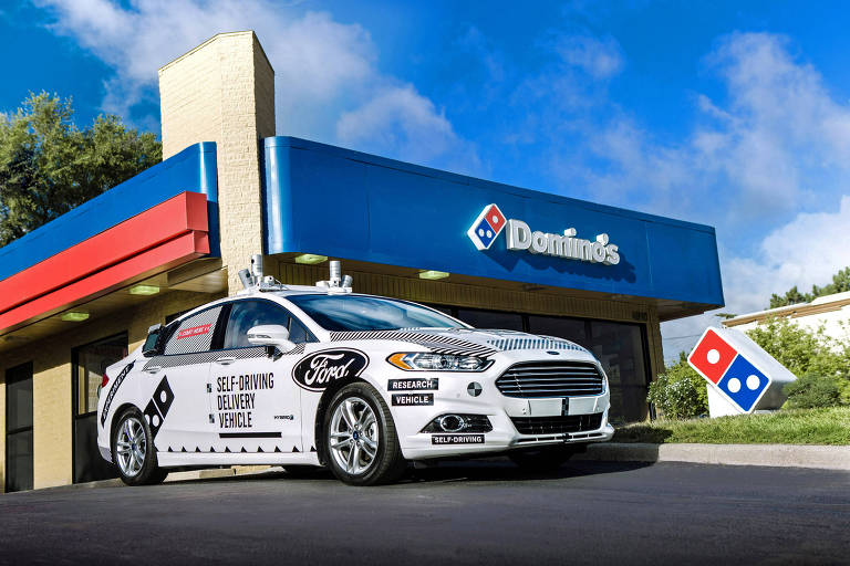 Carro autônomo da Ford em frente a loja da Domino's; empresas criaram parceria para entregar pizza por veículos autoguiado