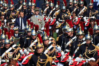 French President Emmanuel Macron and Chief of the Defence Staff French Army General Francois Lecointre arrive in a command car for the traditional Bastille Day military parade on the Champs-Elysees in Paris