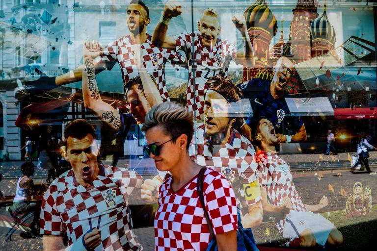 Mulher caminha pelas ruas da capital Zagreb, decorada com as cores da equipe nacional da Croácia