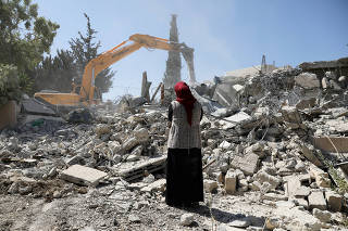 Fawzia stands on the ruins of her house, after her Palestinian ex-husband demolished the dwelling to not face the prospect of Israeli settlers moving in after he lost a land ownership case in Israeli courts