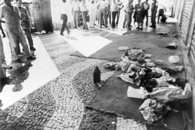 Foto de arquivo em preto e branco mostram colchões e cobertores e moradores de rua espalhados em calçadas