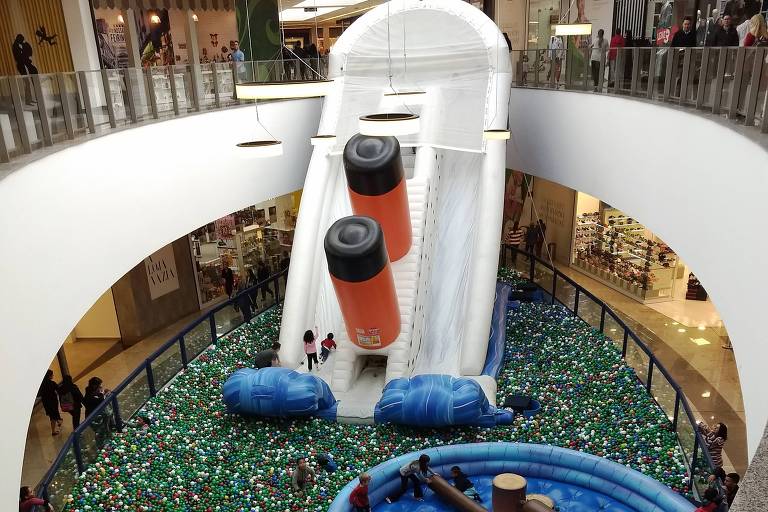 Navio inflável gigante naufragando em piscina de bolinhas dentro do shopping