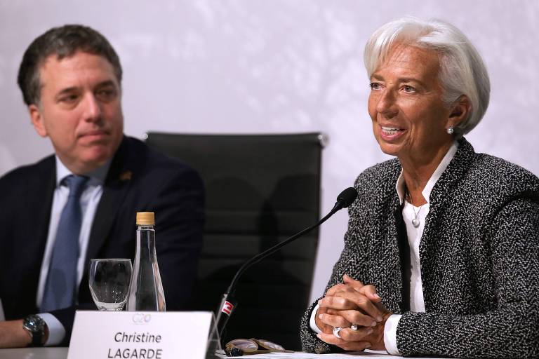 Dujovne e Lagarde sentados em mesa de coletiva de imprensa