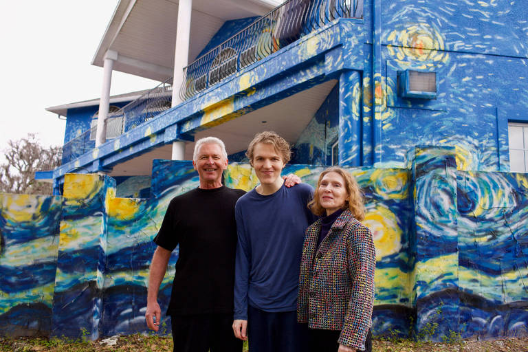 O casal Nancy Nembhauser e Lubomir Jastrzebski com o filho autista, do lado de fora da casa pintada segundo o quadro 'A Noite Estrelada', de Van Gogh